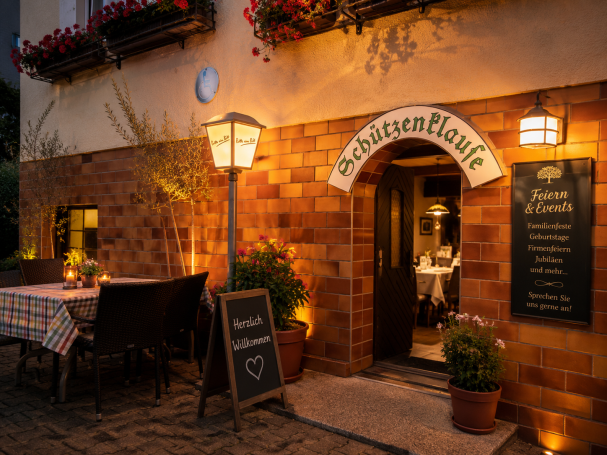 Gemütliches Restaurant mit Außenbereich, sanfter Beleuchtung und Pflanzen.